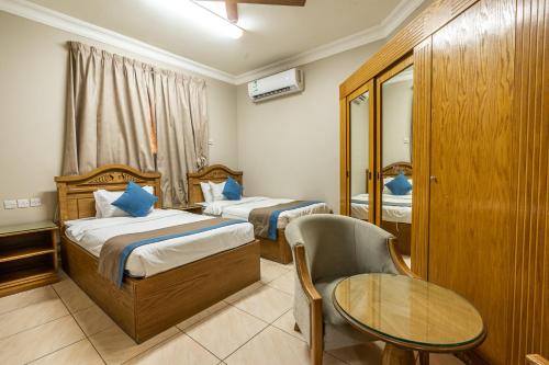 ال متعب سويتس خريص في الرياض: غرفة فندقية بسريرين وطاولة وكرسي