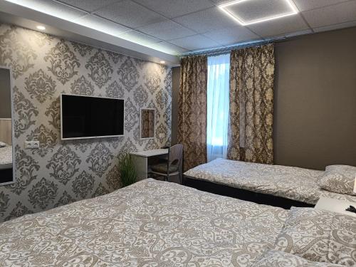 a hotel room with two beds and a flat screen tv at APARTHOTEL in Narva