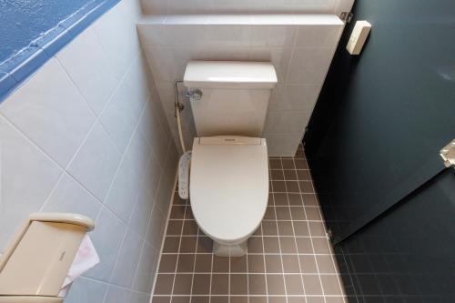 a small bathroom with a toilet in a stall at Residential Hotel Naha Miebashi in Tomari