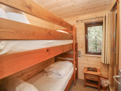 two bunk beds in a log cabin with a window at Canadian Cabin 37 in Keswick