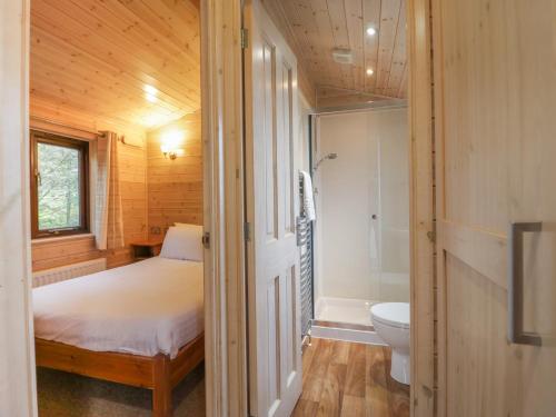 a bedroom with a bed and a bathroom with a toilet at Canadian Cabin 37 in Keswick