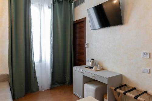 a room with a desk and a television on the wall at Villa Cesi Resort & Spa in Impruneta