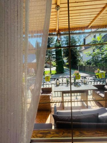 a screened in porch with a table and chairs at Apartament Władek in Biały Dunajec