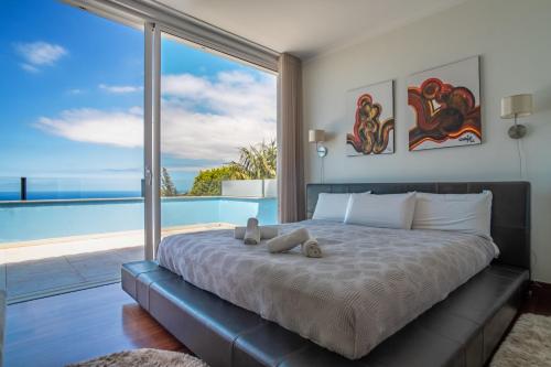 a bedroom with a bed with a view of the ocean at Villa Loureiro Palace With Soccer Field in São Gonçalo