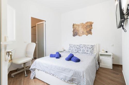 een witte slaapkamer met een bed en een witte stoel bij La Bussola in Las Palmas de Gran Canaria