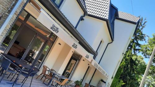 a building with chairs and tables on a patio at Central Room Hostel in Balatonszárszó