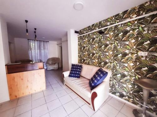 sala de estar con sofá y pared con plantas en Central Room Hostel, en Balatonszárszó