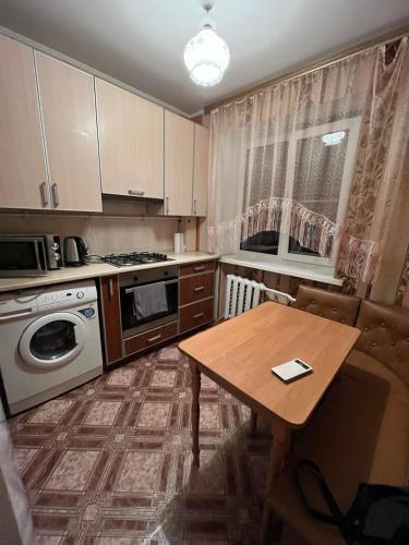 uma cozinha com uma mesa e um fogão forno superior em ПРОСТОРНАЯ СОЛНЕЧНАЯ ДВУХКОМНАТНАЯ квартира em Khmelʼnytsʼkyy