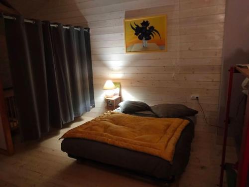 ein Schlafzimmer mit einem Bett mit einer braunen Decke in der Unterkunft Le Chouette loft 