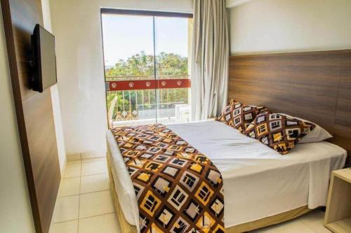 a bedroom with a bed with a large window at BARRETOS COUNTRY in Barretos