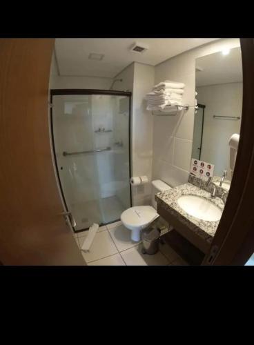 a bathroom with a shower and a toilet and a sink at BARRETOS COUNTRY in Barretos
