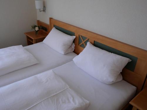 two beds with white pillows sitting next to each other at Bocksbeutelherberge in Sommerach