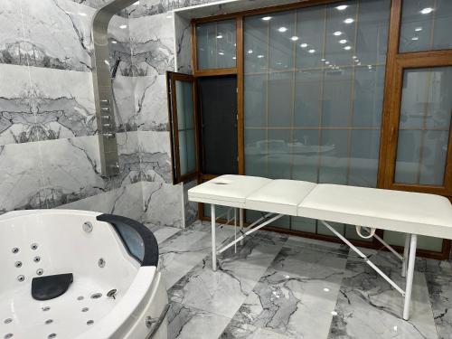 y baño con bañera blanca y lavamanos. en Katej en Quba