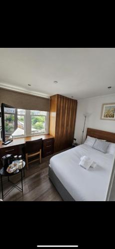 a bedroom with a large white bed and a table at Cosy Double Room City Centre in Edinburgh