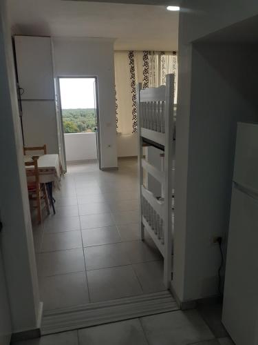 a hallway with a staircase and a room with a window at Borsh Amantius Apartments in Himare
