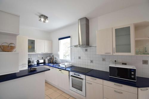 une cuisine avec des armoires blanches et des comptoirs bleus dans l'établissement Estrella - Hossegor centre ville magnifique appartement avec parking, à Soorts-Hossegor