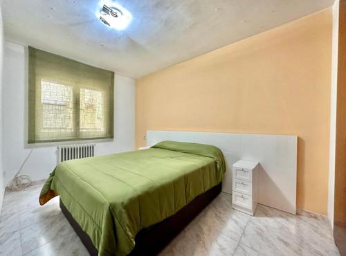 a bedroom with a green bed and a window at Apto. grande, luminoso y centrico in Olot