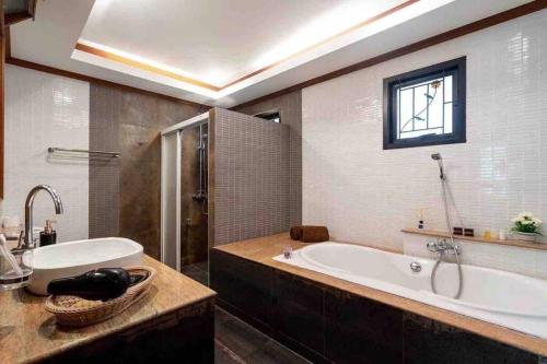 a bathroom with a large tub and a sink at 6BR Laguna Bangtao Seaside Swimming Pool Villa in Phuket Town