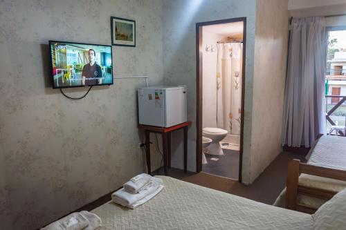 a room with two beds and a tv on the wall at Hotel Ibiza in Villa Gesell