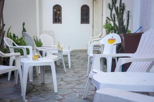 a group of white tables and chairs on a patio at Hotel Ibiza in Villa Gesell