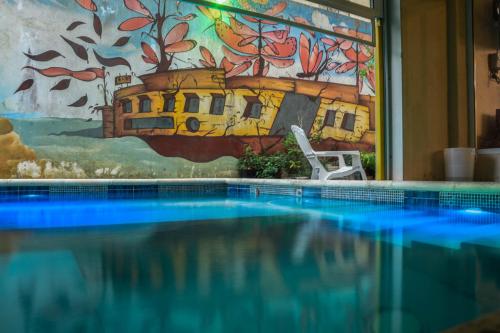 una piscina frente a una pintura de un barco en el Hotel Ibiza en Villa Gesell