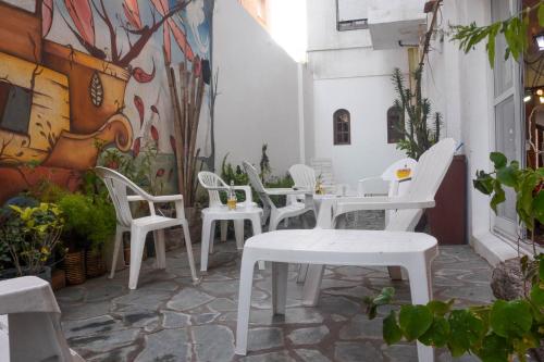 a group of white chairs and tables on a patio at Hotel Ibiza in Villa Gesell