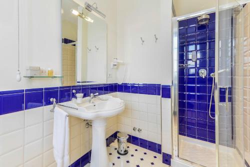 a blue and white bathroom with a sink and a shower at Relais Paradiso Resort & Spa in Gualdo Cattaneo