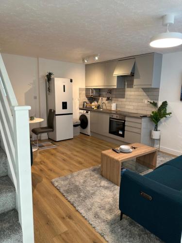 a living room with a blue couch and a kitchen at Dartford Luxurious House with Parking - Netflix - Wi-Fi in Kent