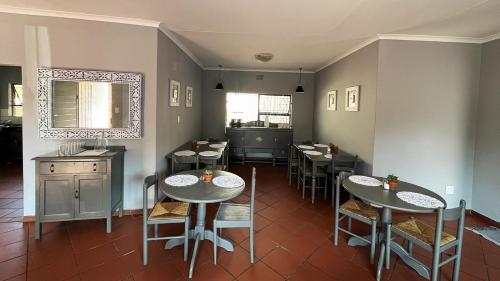 Pretoria的住宿－The Wild Peach - Menlyn，一间在房间内配有桌椅的餐厅