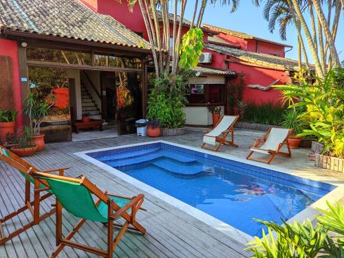 a patio with a pool and chairs and a house at Pousada Villegaignon in Búzios