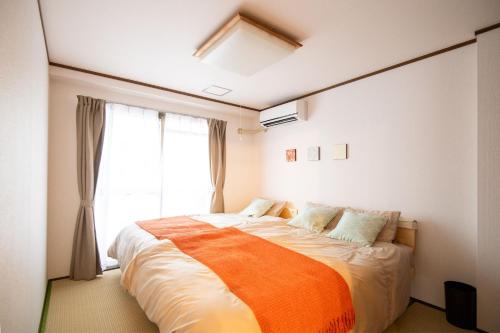 1 dormitorio con 1 cama grande y ventana en Nature Flower House in Ohanajaya, en Tokio