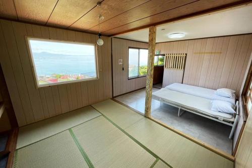 Habitación pequeña con cama y ventana en 谷地頭温泉近く！ピアノのある一軒家（English OK） en Hakodate