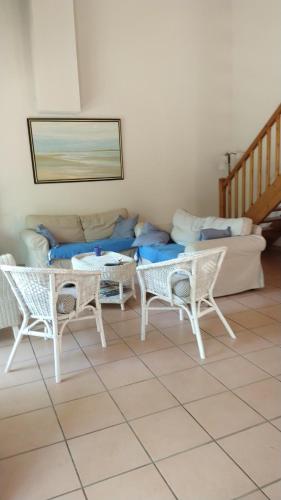 un salon avec un canapé, une table et des chaises dans l'établissement Carpe diem bis, à Gujan-Mestras