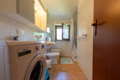 ein Badezimmer mit Waschmaschine und Toilette in der Unterkunft Songavazzo Dream Apartment in Songavazzo
