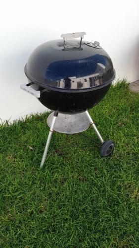 a grill sitting on top of the grass at Spacious loft in Paternoster