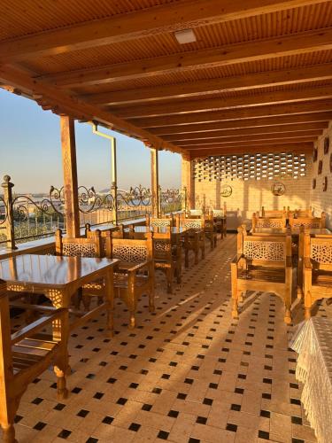 a restaurant with wooden tables and chairs on a roof at Hotel Zarhal in Bukhara