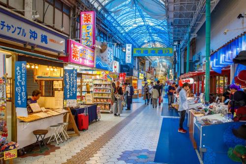 a market with people walking around in a building at Residential Hotel 183 Naha in Naha