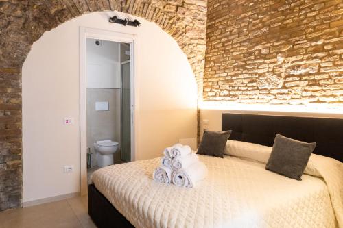 ein Schlafzimmer mit einem Bett und einer Ziegelwand in der Unterkunft [Loft Rustico] in Centro Storico in Assisi