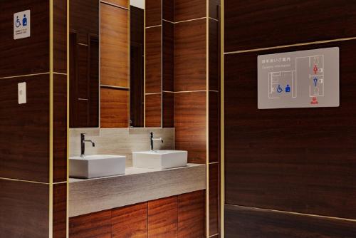 uma casa de banho com 2 lavatórios e paredes de madeira em Folio Sakura Shinsaibashi Osaka by Banyan Group em Osaka