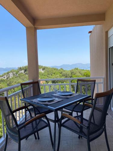 un tavolo e sedie su un balcone con vista di Apartments D&D a Osobjava