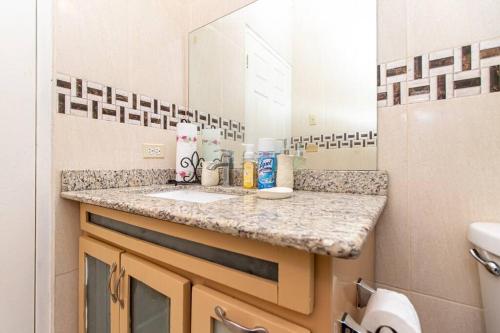 W łazience znajduje się umywalka i lustro. w obiekcie J&R Sunshine Retreat w mieście Spanish Town
