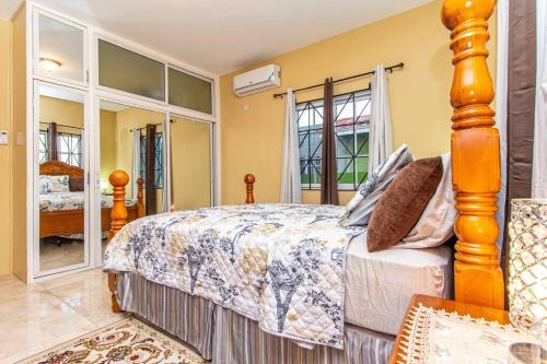 sypialnia z dużym łóżkiem i dużym oknem w obiekcie J&R Sunshine Retreat w mieście Spanish Town