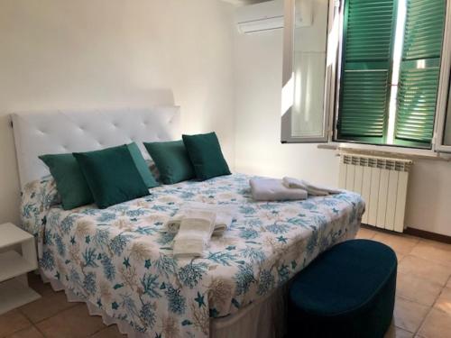 a bedroom with a large bed with green pillows at Attici Agli Acquedotti Romani in Rome