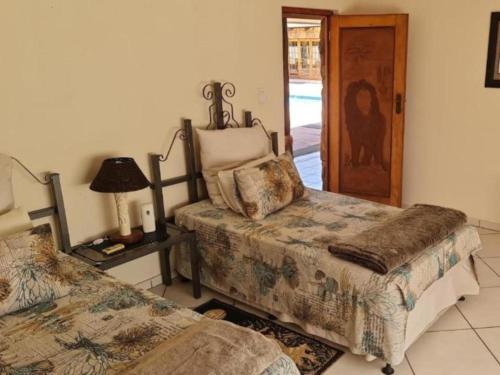 a bedroom with two beds and a lamp and a door at The Sanctuary - Self Catering Accommodation in Mtubatuba