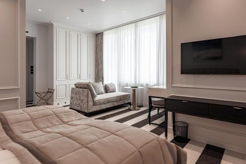 ein Hotelzimmer mit einem Bett und einem TV in der Unterkunft Hotel Balkan in Belgrad