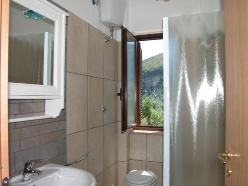 baño con lavabo y aseo y ventana en Residence Tre Mulini, en Scario