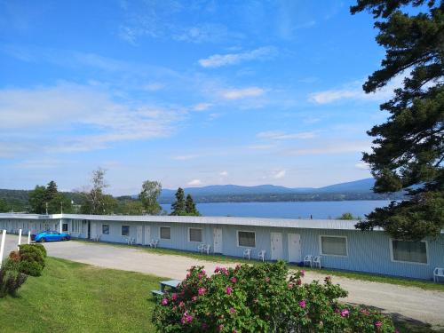 une rangée de bâtiments avec un lac en arrière-plan dans l'établissement Motel & Camping Fort Ramsay, à Gaspé