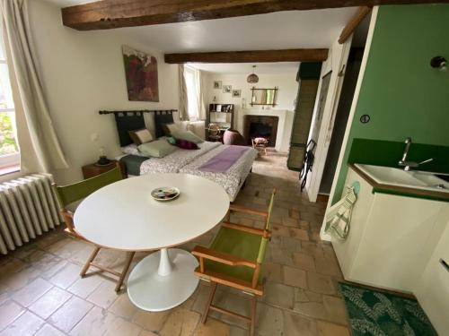 AMALOUYSE Studio de charme au cœur des châteaux de Loire في مونتلويس سور لوار: مطبخ وغرفة معيشة مع طاولة وأريكة
