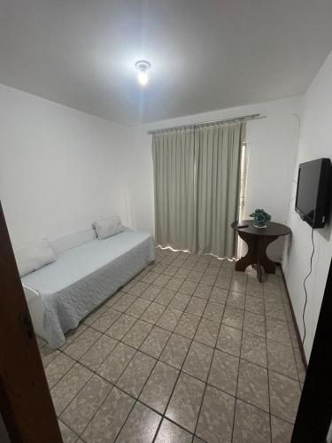 ein Schlafzimmer mit einem Bett und einem Fernseher in der Unterkunft APARTAMENTO PARA 4 ADULTOS EM BALNEARIO CAMBORIU in Balneário Camboriú