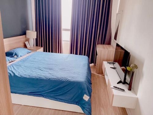 a bedroom with a bed with a blue comforter at Cozy apartment 2BR - Masteri Thao Dien , D2 in Ho Chi Minh City